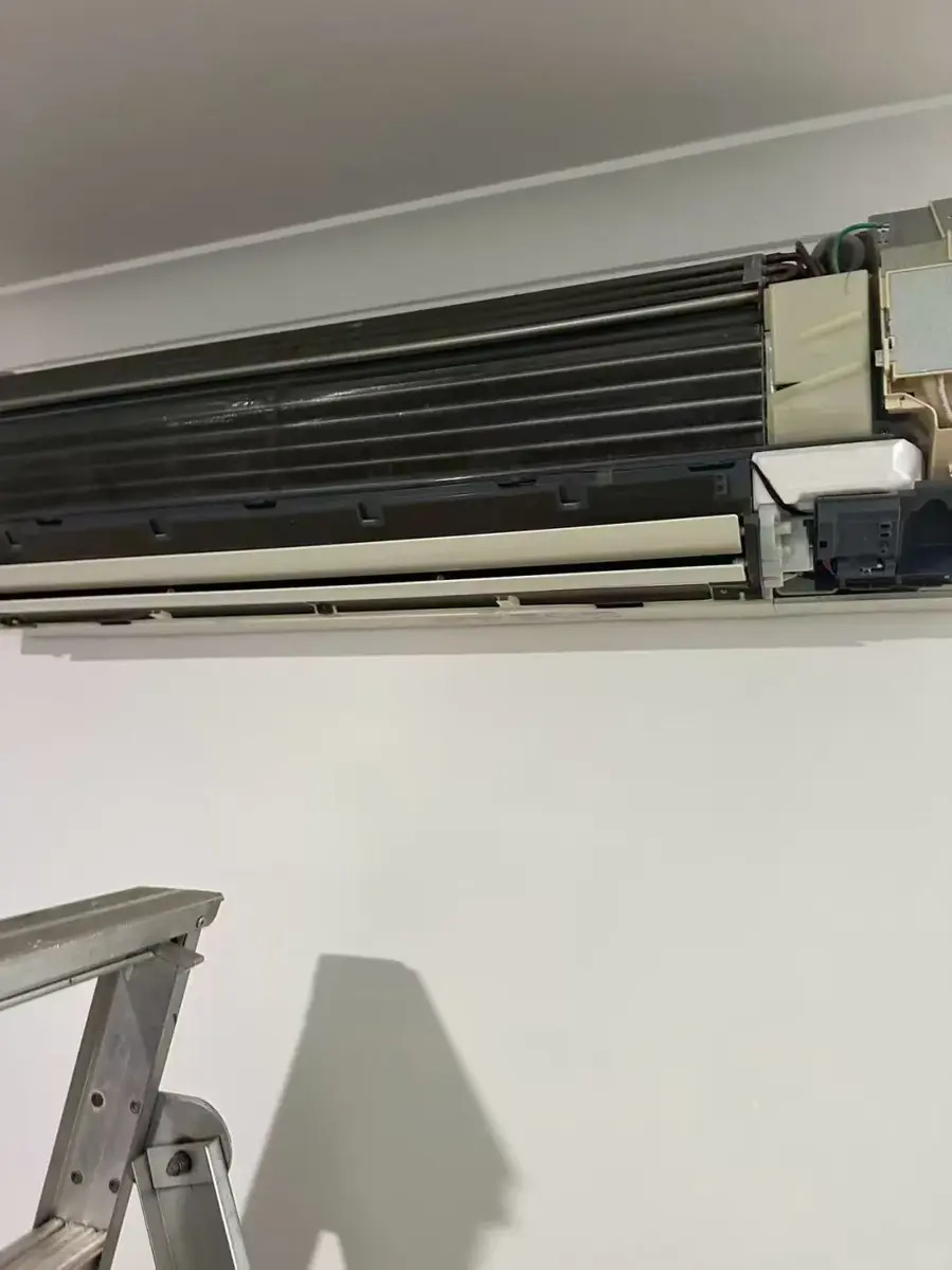Opened indoor wall-mounted air conditioner during service access