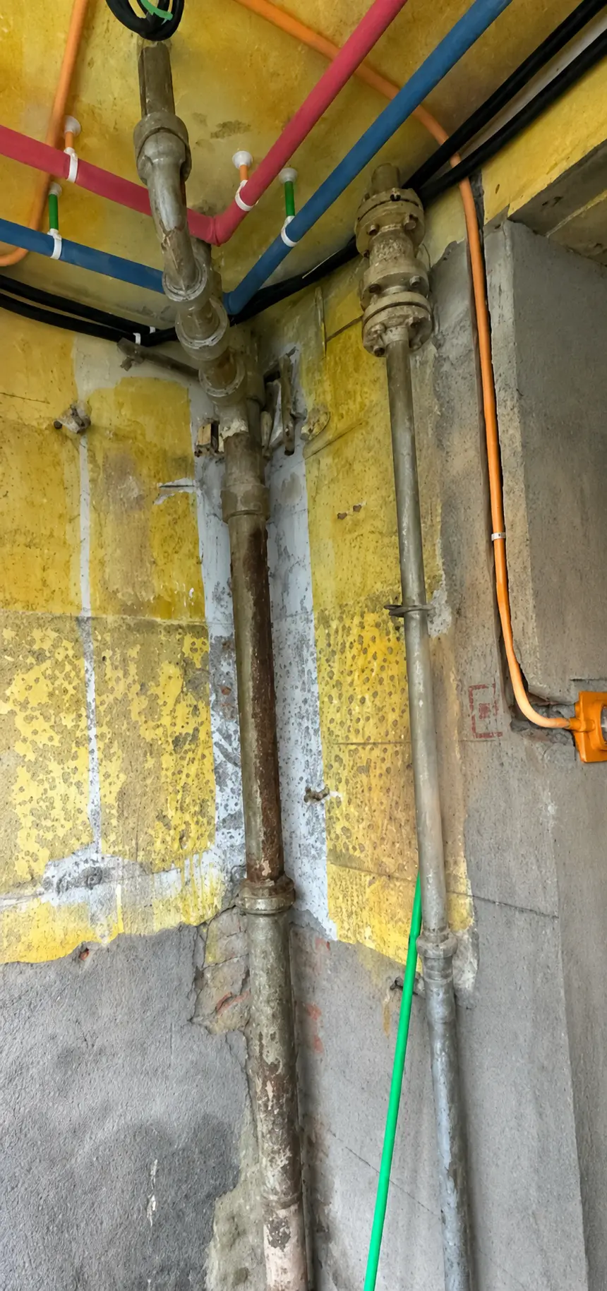 Aged vertical pipework with visible surface deterioration